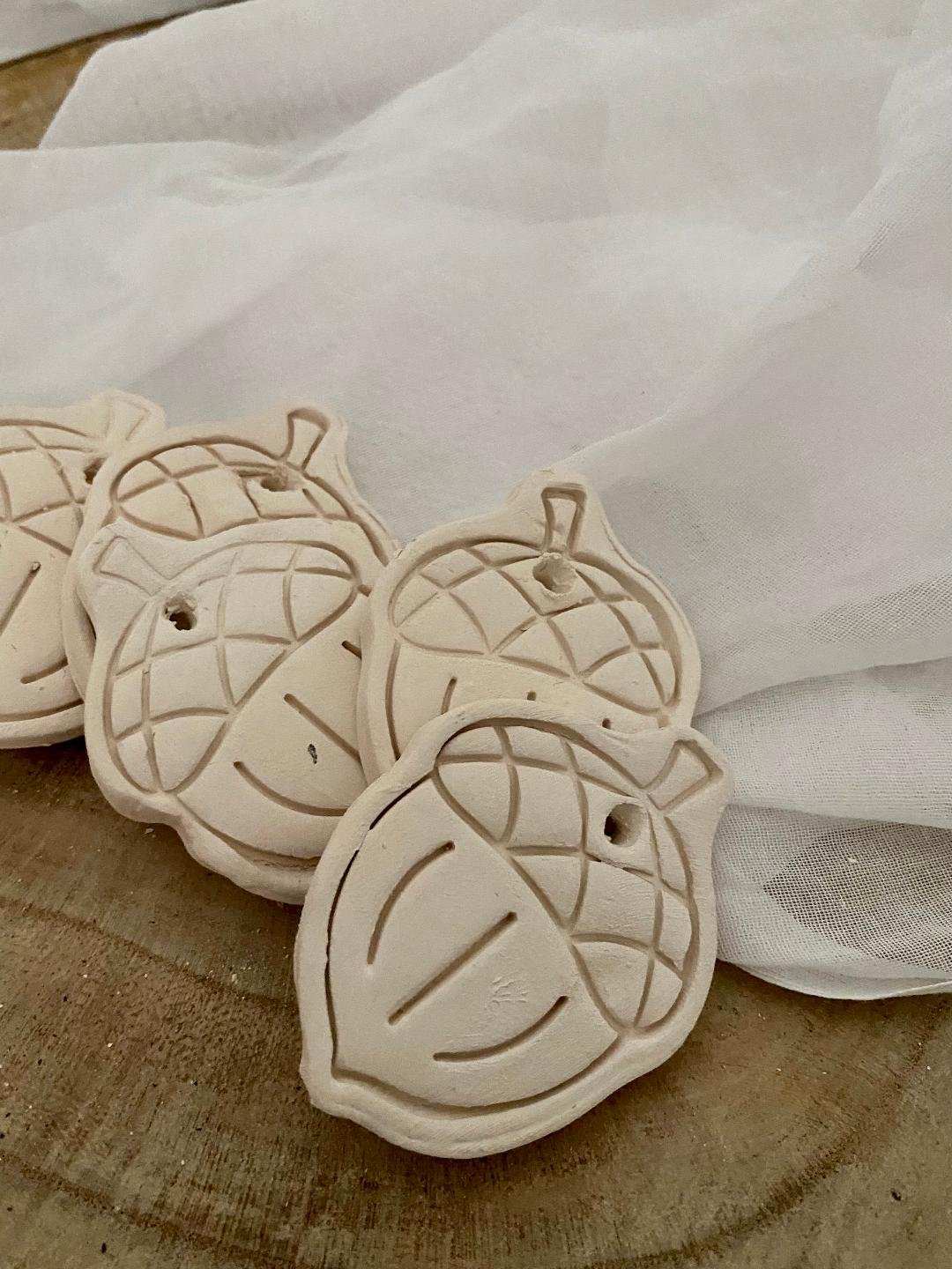 Set of six handmade white ceramic acorn decorations from the autumn collection