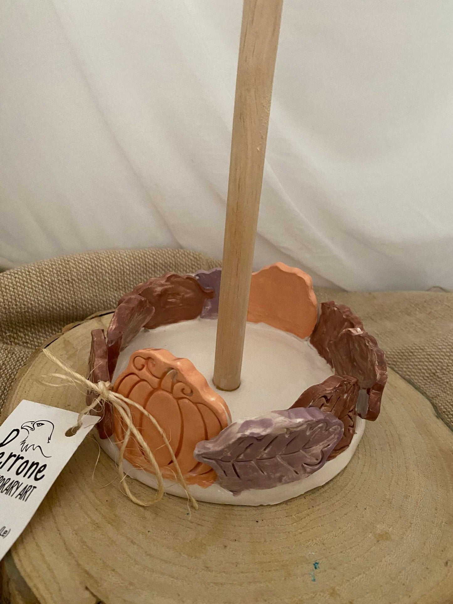 white ceramic and wood paper towel holder with autumn leaf and pumpkin decorations