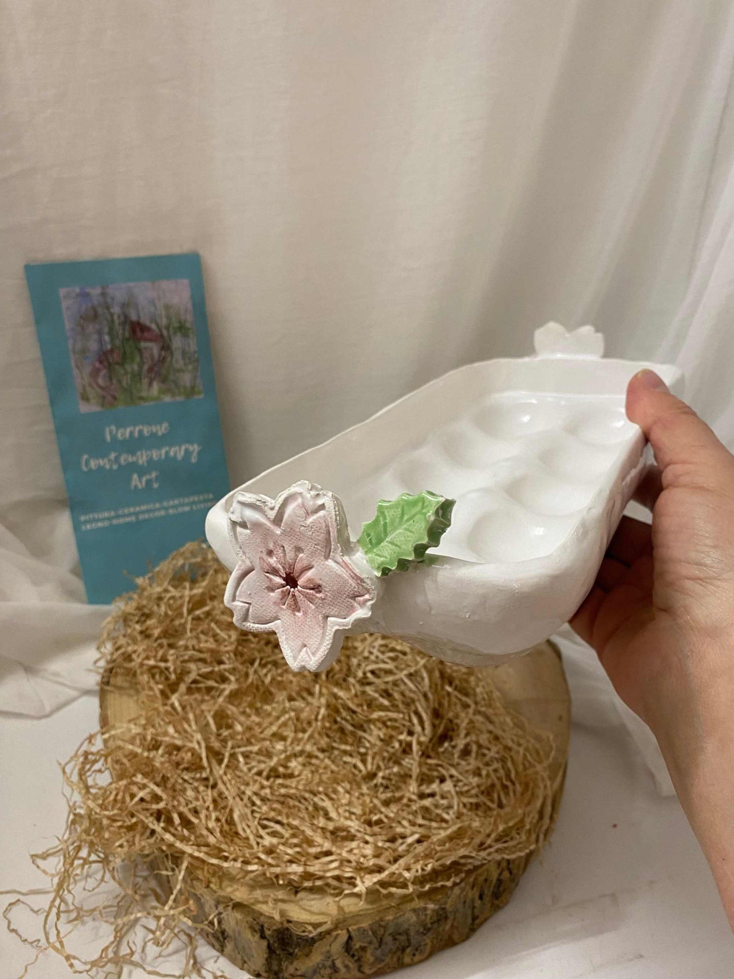 White ceramic egg holder with floral decoration, designed to hold 10 eggs, elegant and handcrafted.