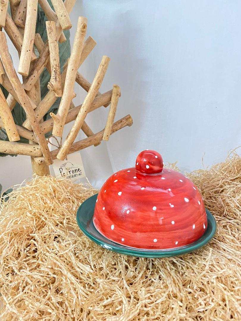 Hand-painted red polka dot ceramic butter dish from Fruit Collection on natural straw background