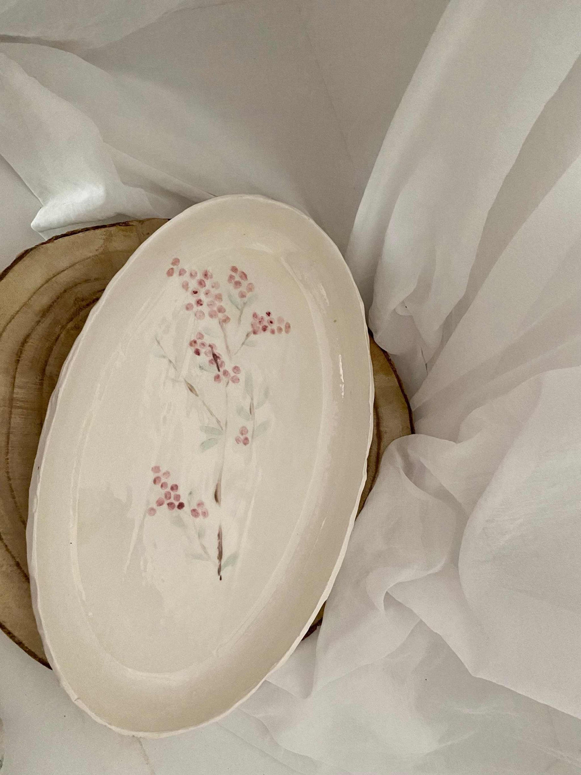 Elegant white ceramic Vassoio Collezione Sakura tray with delicate pink cherry blossom design on oval shape.