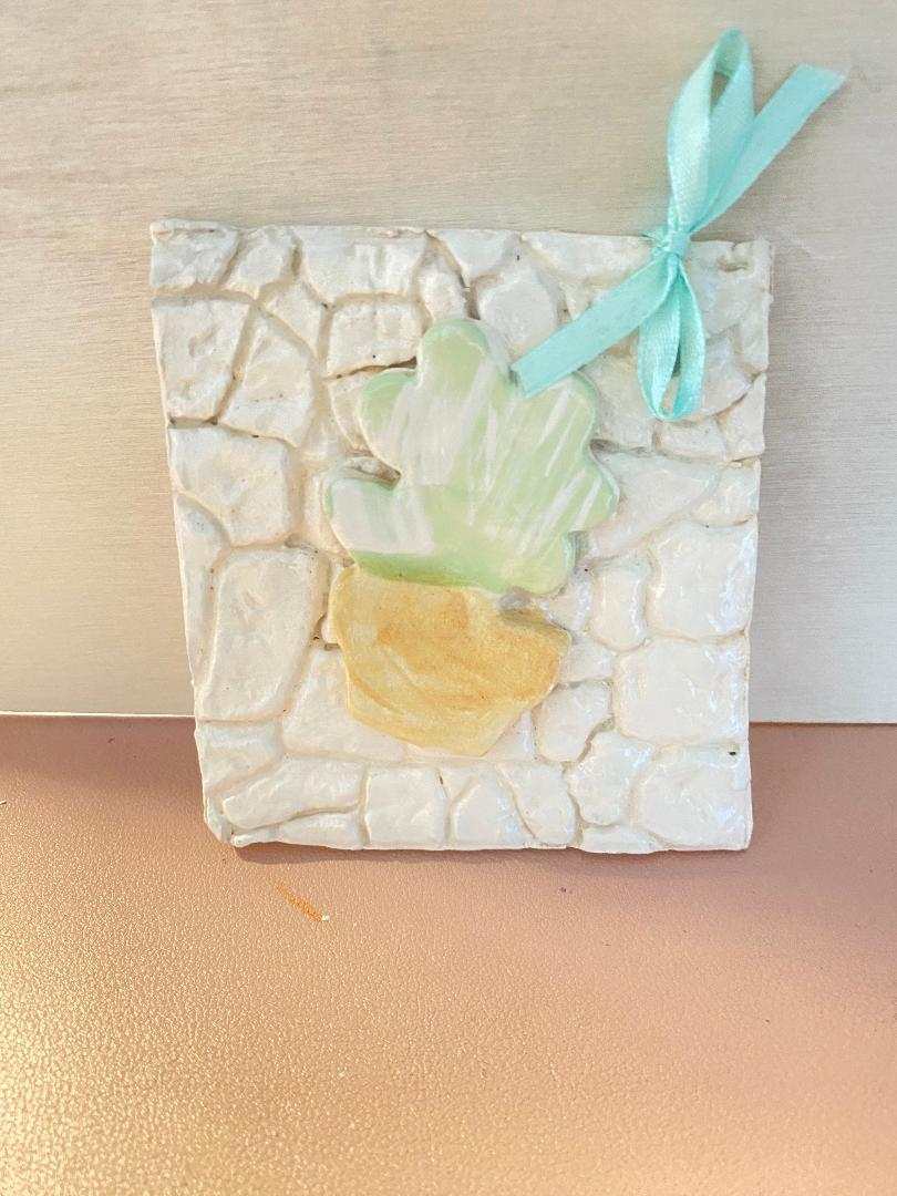 Ceramic tile from Gocce del Salento collection with plant design and decorative ribbon