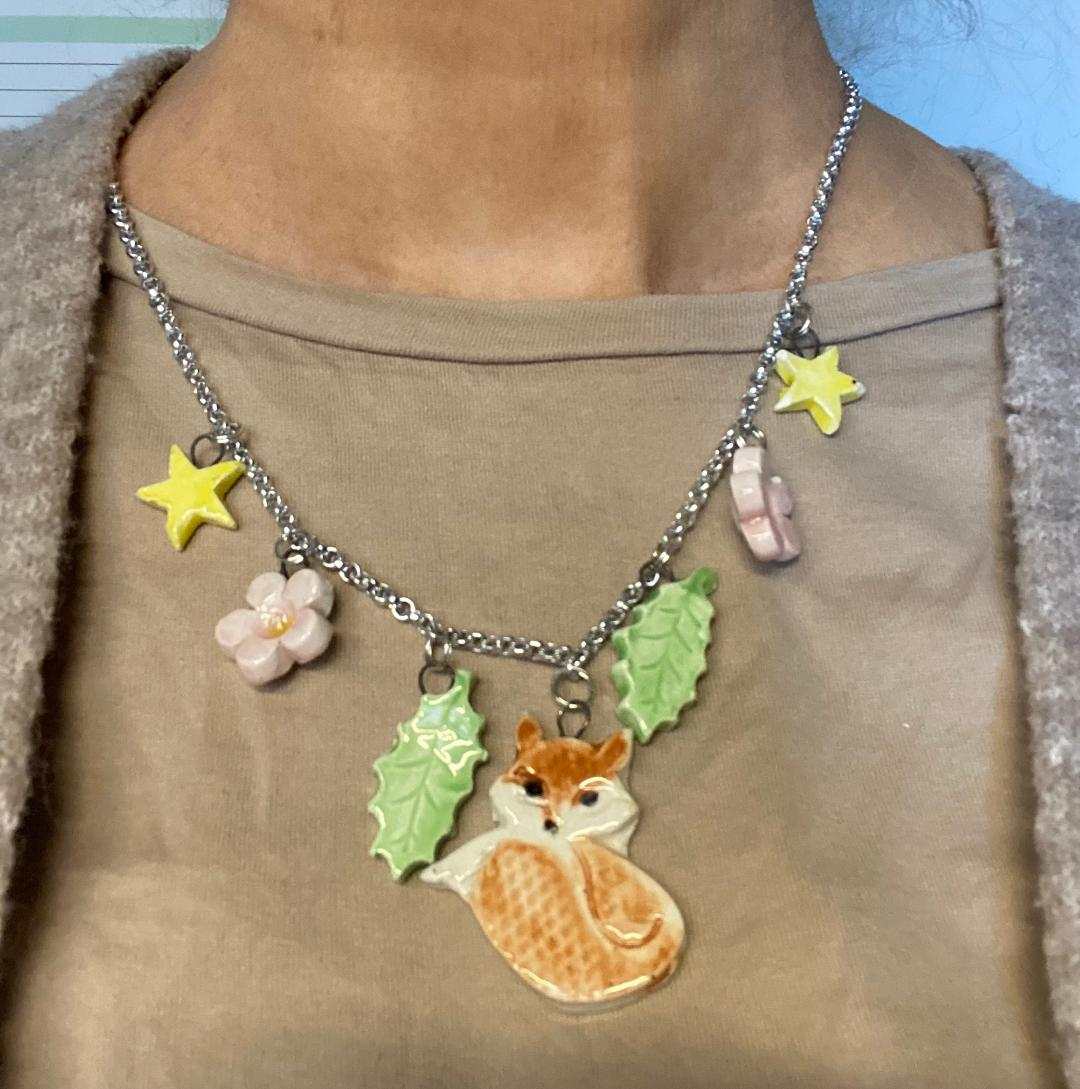 Collana Collezione Luxury Bijoux stainless steel necklace with hand-painted ceramic charms featuring a fox, green leaves, flowers, and yellow stars.